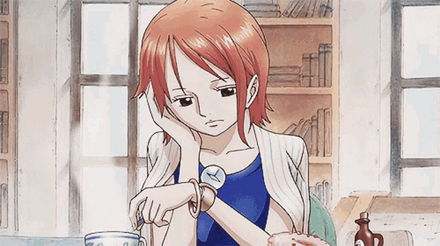 a girl with orange hair is sitting at a table with a cup