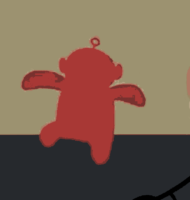 a red teddy bear is being punched by a white hand .