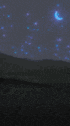 a couple sitting next to each other under a starry night sky with a blue light projected on the ground .