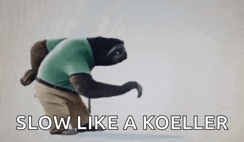 a stuffed animal of a sloth wearing a green shirt and khaki pants is walking with a cane .