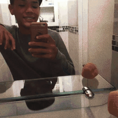 a young man taking a selfie in a bathroom