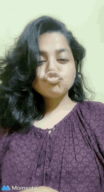 a woman in a purple shirt is making a funny face with her mouth open