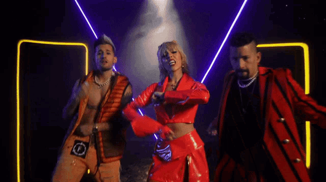 two men and a woman are dancing in a dark room