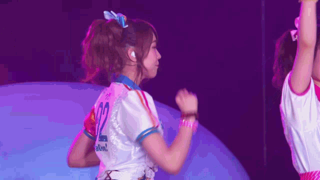 a girl with the number 12 on her shirt is dancing