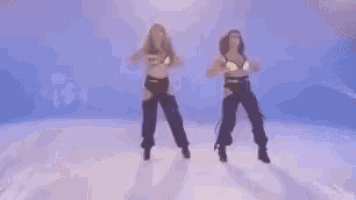 two women are dancing on a ice rink .