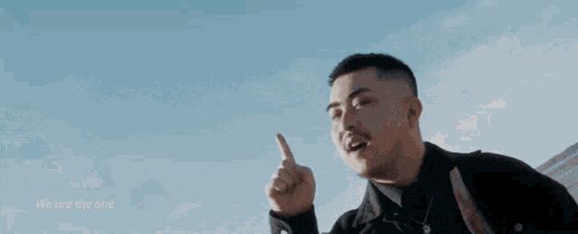 two men are standing in front of a blue sky and one is pointing