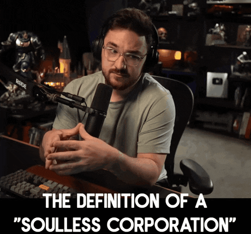 a man wearing headphones talks into a microphone with the words " the definition of a soulless corporation " below him