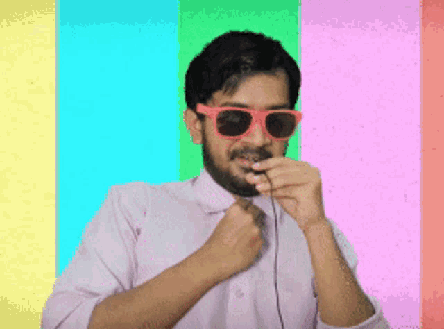 a man wearing pink sunglasses and a tie is adjusting his tie