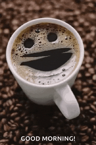 a cup of coffee with a smiley face on it is on a pile of coffee beans .