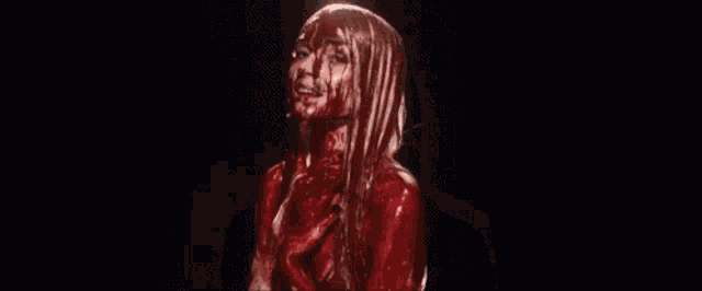 a woman with blood on her face and body .