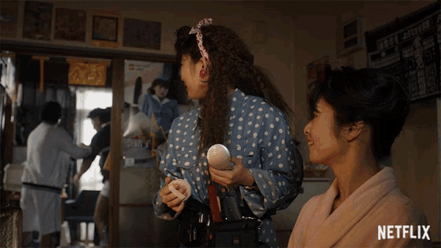two women are standing in a room with a netflix logo on the bottom right