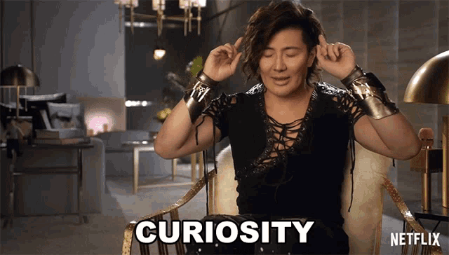 a woman is sitting in a chair with curiosity written on her face
