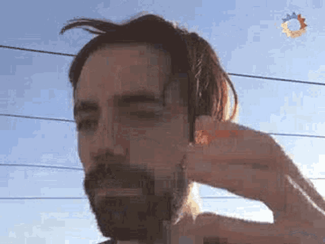 a man with a beard is holding a piece of paper in his hand .