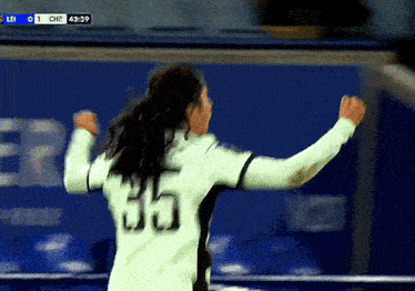 a soccer player with the number 65 on her jersey celebrates