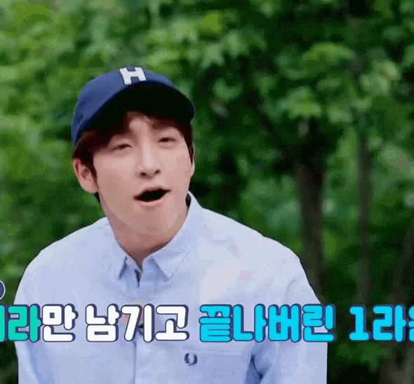 a man wearing a baseball cap with the letter h on it is making a funny face