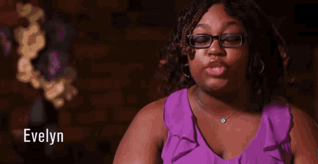a woman wearing glasses and a purple top with the name evelyn on the bottom
