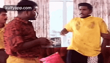 three men are standing next to each other in a living room .