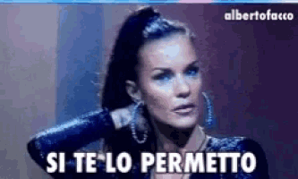 a woman in a black dress is standing in front of a sign that says si te lo permetto