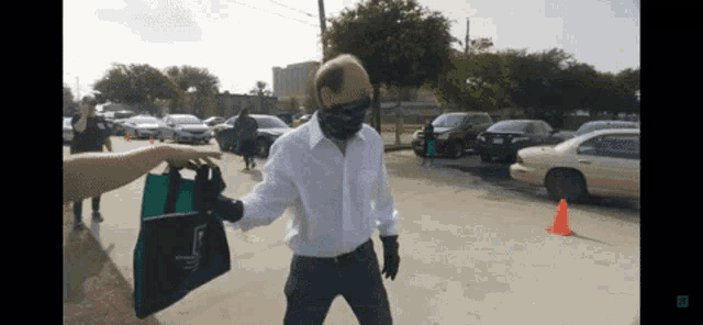 a man wearing a face mask is being helped by a woman holding a bag that says ' abercrombie '
