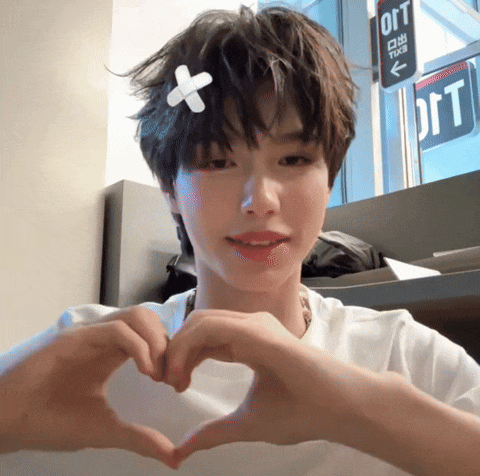a young man making a heart shape with his hands