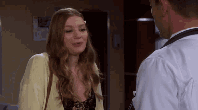 a woman in a yellow jacket is talking to a man in a white coat