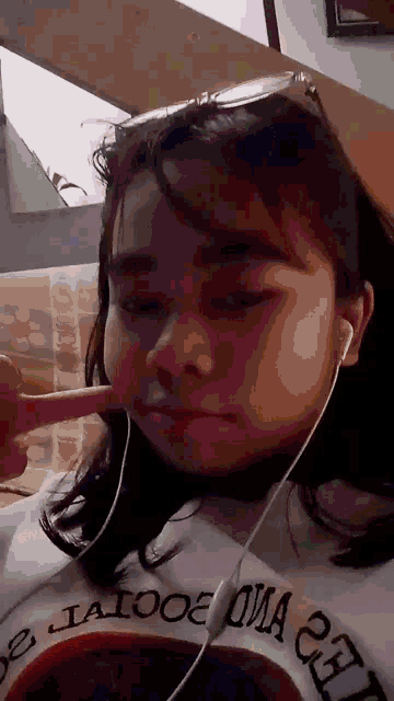 a girl wearing ear buds and a shirt that says california on it