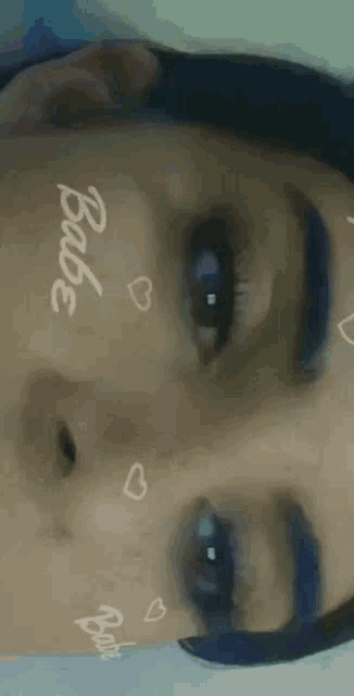 a close up of a woman 's face with the word babe written on her face
