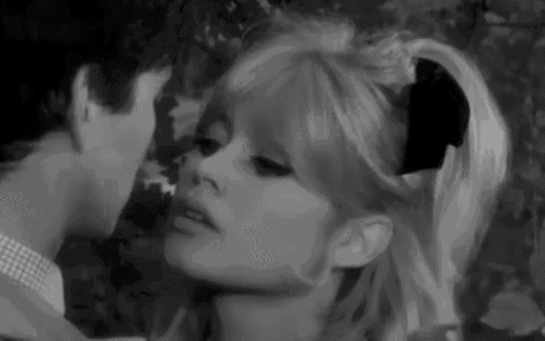 a man and woman are kissing in a black and white photo .
