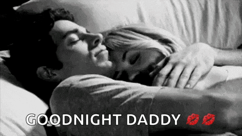 a man and a woman are laying in bed hugging and kissing each other .