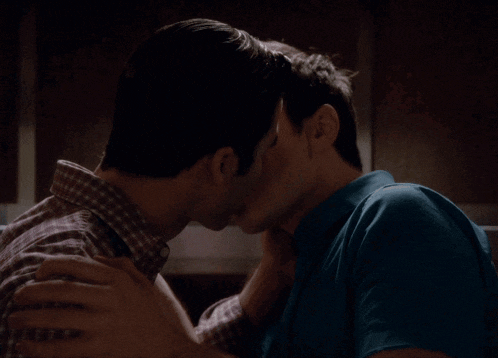a man in a plaid shirt is hugging another man