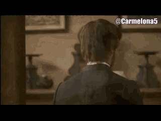 a man in a suit is standing in a room with the name jord coll on his back