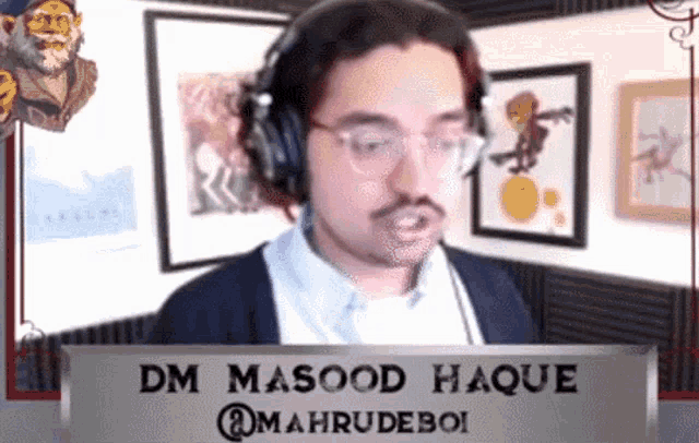 a man wearing headphones and glasses is standing in front of a sign that says dm masood haque