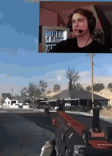 a man wearing headphones is playing a video game with a red gun