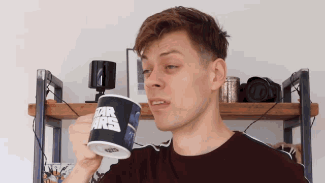 a man drinks from a star wars mug