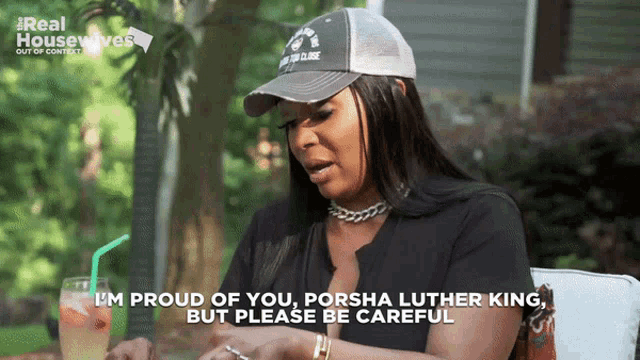 a woman wearing a hat says " i 'm proud of you porsha luther king "