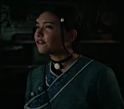a close up of a woman 's face with a choker around her neck