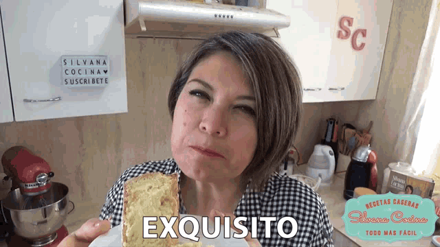 a woman is holding a piece of bread in front of a sign that says " exquisito "