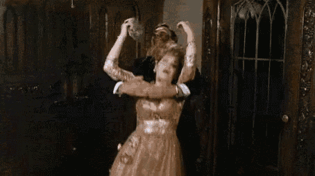 a woman in a gown is dancing with a man in a tuxedo .