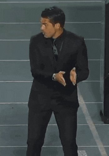 a man in a suit and tie is pointing at something