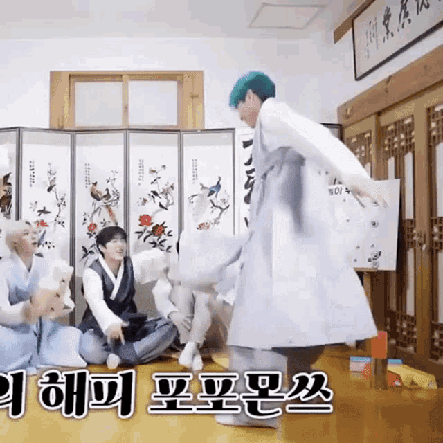 a group of people are sitting on the floor in a room with chinese writing on the wall