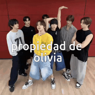a group of young men are standing next to each other with the words propiedad de olivia written above them