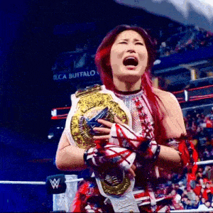 a female wrestler is crying while holding a world heavyweight championship