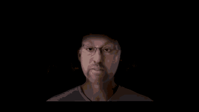 a man 's face is projected onto a screen with a glowing city