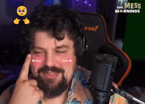 a man with a beard is wearing headphones in front of a seat chair