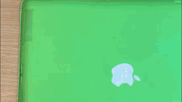 a person is holding a cell phone in front of an apple logo on a green background .