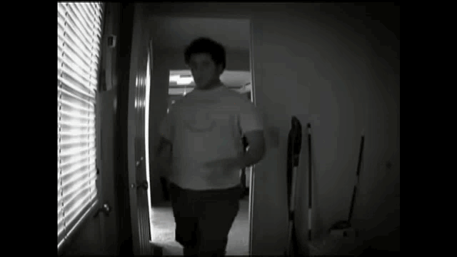 a man in a white shirt is standing in a hallway