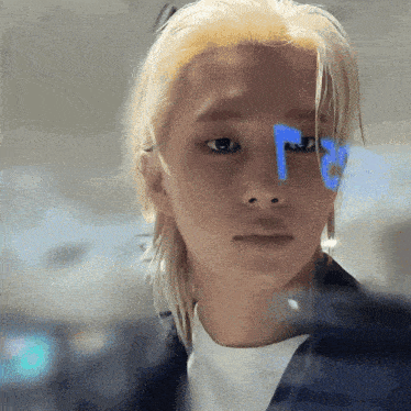 a close up of a man 's face with a blue r on his forehead