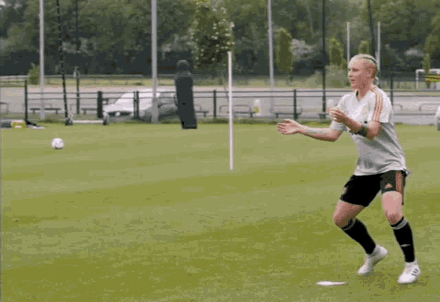 a soccer player wearing an aon jersey kicks a ball