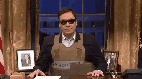 a man wearing sunglasses and a vest that says kushi