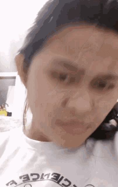 a close up of a woman 's face wearing a white shirt .
